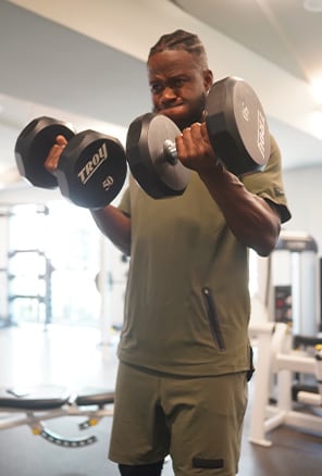Coach is lifting 50 lbs dumbells